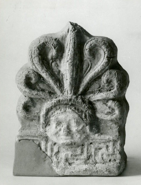 002711 - reperto - Casa Repubblicana a fianco delle Scalae Caci (sud-ovest della Casa di Livia), nel muro di fondazione in opus caementicium M che copriva la parete occidentale del IV ambiente della casa repubblicana e del terreno di scarico addossato a detta parete (recupero di numerose terracotte), durante gli scavi del Carettoni del 1956.  
Antefissa (altezza cm 22,5; larghezza cm 16) decorata con palmetta nascente da una mascherina muliebre. Sopra l'originaria policromia in bianco ed azzurro e uno strato di colore bianco e viola, malamente applicato. Manca parte della decorazione del meandro di base. 

Bibliografia: Carettoni, G.F. in NsC 1967 pag.312

Neg. serie 6x6 nÂ°1261