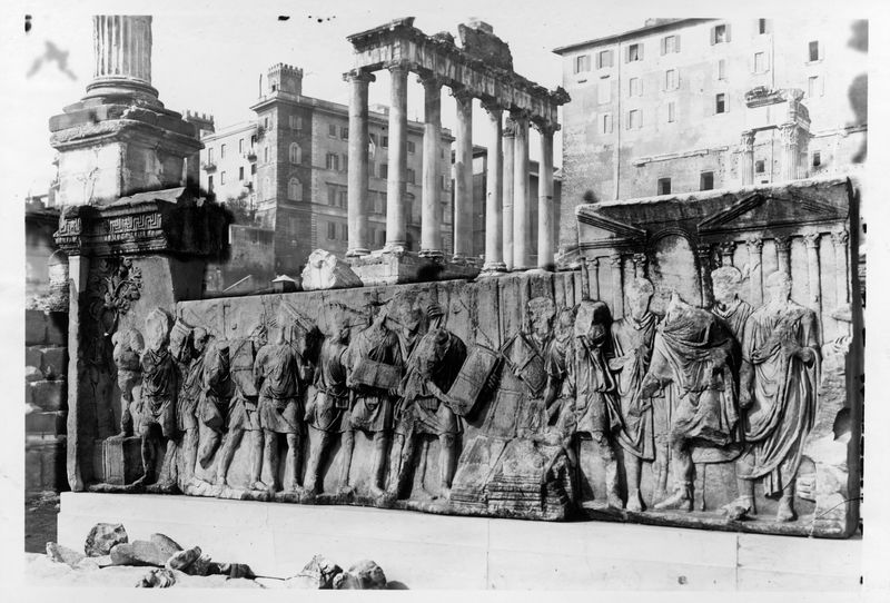 015851 - monumento - Foro Romano, Plutei di Traiano, il rilievo con il condono dei debiti con, in secondo piano, il Tempio di Saturno; FILM 1494, n. 161