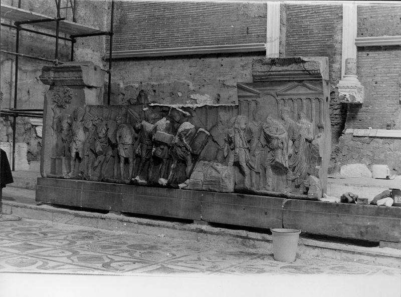 015862 - monumento - Foro Romano, Plutei di Traiano, il rilievo con il condono dei debiti, ripresa all'interno della Curia; FILM 648, n. 20A