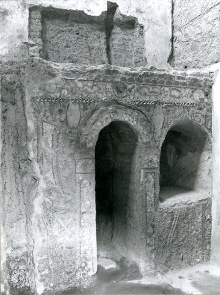 001967 - monumento - Casa di Augusto, piccolo ninfeo: misura m 2,20 di lunghezza, tagliato ai lati da muri augustei. E' decorato con paste vitree e conchiglie le quali incorniciano la fronte, dove sono rappresentati due timoni e due ancore (?).  Nella parete sono stati ricavati un cunicolo e una nicchia. Probabilmente risalente all'epoca repubblicana. Bibliografia: "Augusto sul Palatino. Gli scavi Carettoni (1955-1984). Appunti inediti"
Neg. serie Film nÂ° 1001