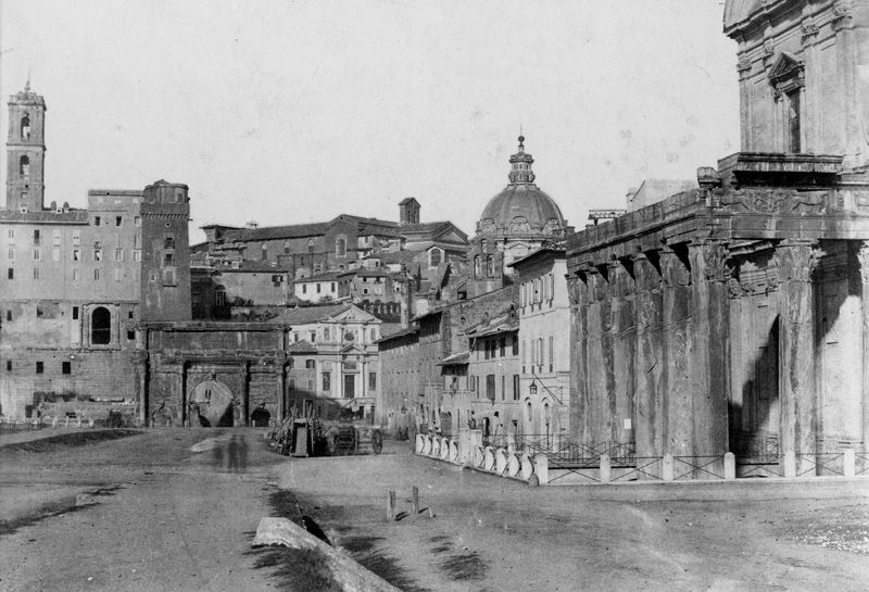 019827 - monumento - Tempio di Antonino e Faustina, veduta del angolo orientale del colonnato e della Via Sacra prima degli scavi, sullo sfondo l'Arco di Settimio Severo